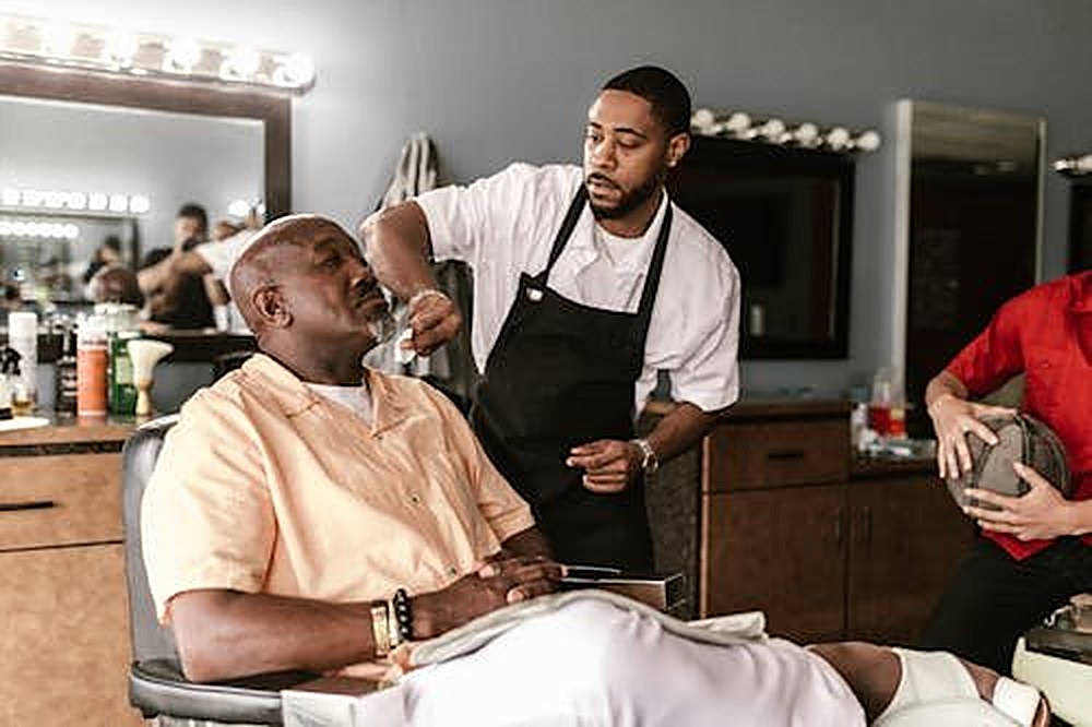 Men gathered at a barbershop, a space of community, trust, and connection for men of color